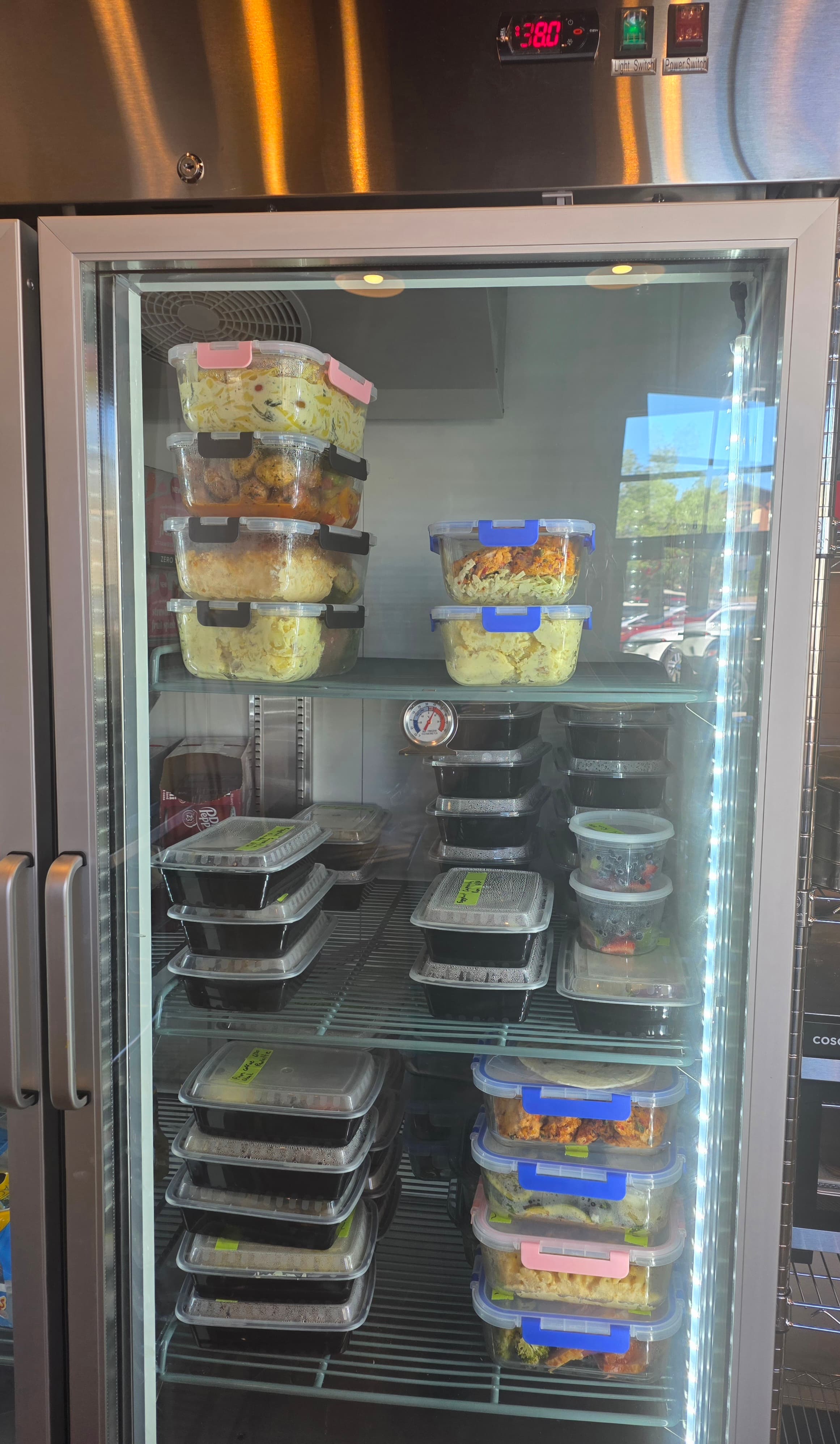 Prepared meals organized in the pickup cooler at The Unseen Chef Studio