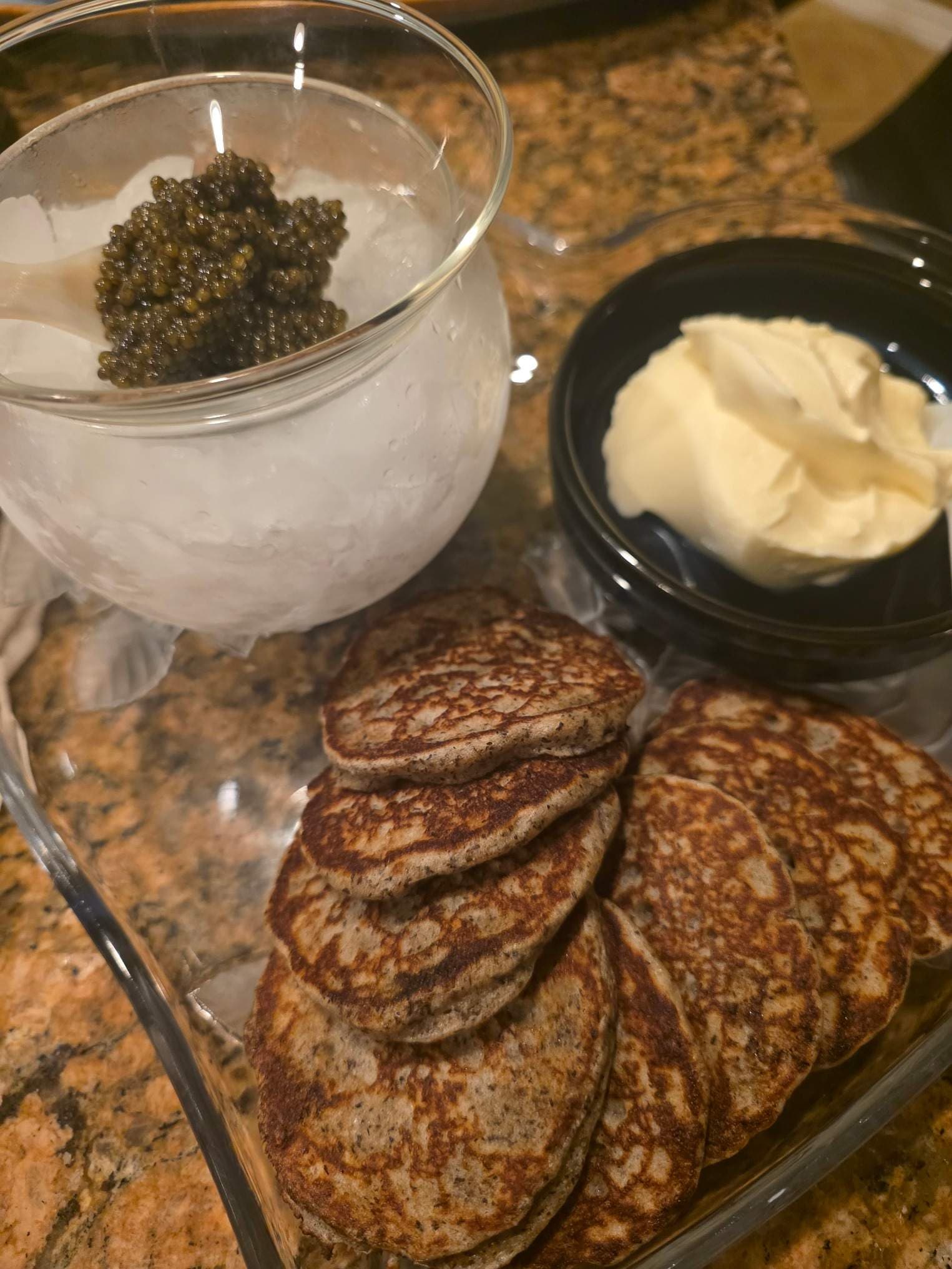 Caviar, crème fraîche, and blini prepared for a private dining course