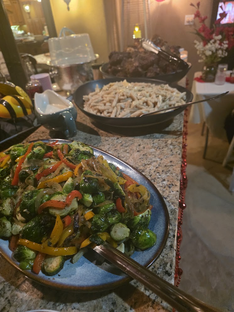 A catered buffet with vegetables, pasta, and braised meats
